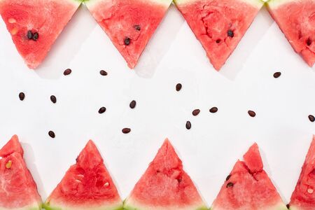 flat lay with delicious juicy watermelon slices and seeds on white backgroundの写真素材