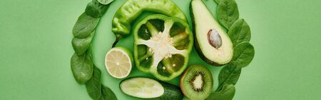 panoramic shot of peppers, cucumber, kiwi, lime, greenery and avocado