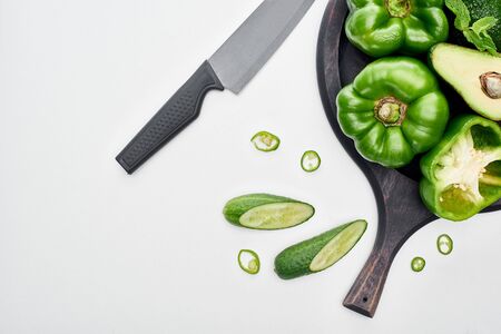 top view of knife, avocado, peppers, cucumbers and greenery on pizza skilletの写真素材