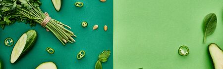 panoramic shot of fresh and cut cucumbers, peppers and greenery