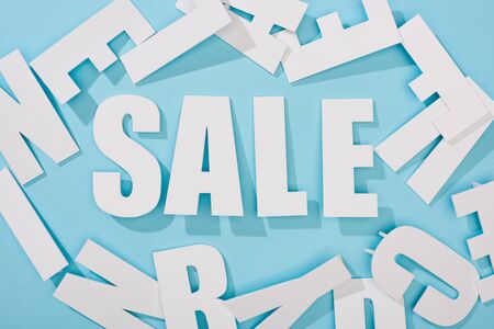 top view of white sale lettering among letters on blue backgroundの写真素材