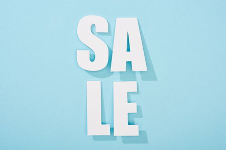 top view of white sale lettering on blue background with copy spaceの写真素材