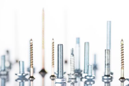 close up view of shiny metallic studs and bolts isolated on whiteの写真素材