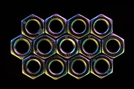 close up view of shiny metal nuts isolated on blackの写真素材