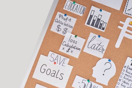 top view of cards with financial notes and charts pinned on office cork boardの写真素材