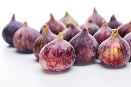 selective focus of ripe whole delicious figs on white background