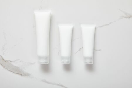 top view of cosmetic cream tubes on white surfaceの写真素材
