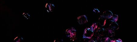 panoramic shot of transparent ice cubes with purple light isolated on black