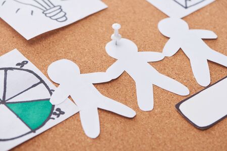 paper artwork pinned on cork office board