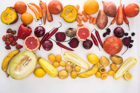 top view of assorted raw colorful autumn vegetables, berries and fruit on white backgroundの写真素材