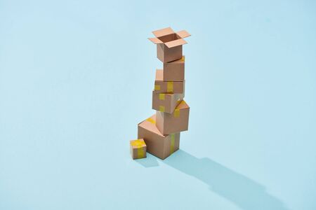 tower of miniature boxes on blue background with copy spaceの写真素材