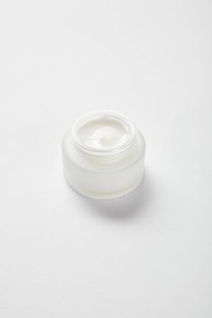 open glass jar with face cream on whiteの写真素材