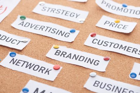 paper cards with price, promotion, advertising, customers, branding, network inscriptions pinned on cork office boardの写真素材