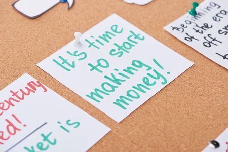 paper card with work motivation message pinned on cork office board