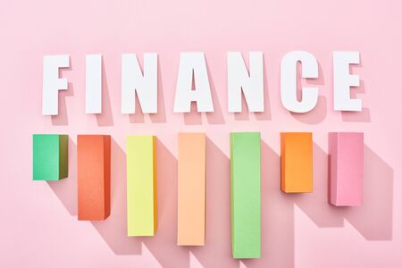 top view of finance inscription with color block graph on pink backgroundの写真素材