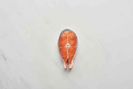 top view of raw fresh salmon steak on white marble surfaceの写真素材