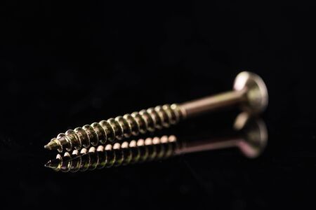 close up view of shiny metal stud isolated on black