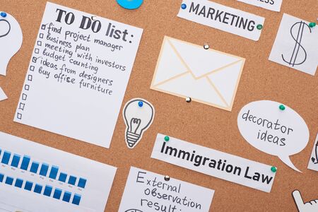 top view of cards with work to-do notes pinned on office cork board