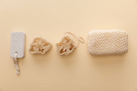 top view of natural bath sponge near loofahs and pumice stone on beige background