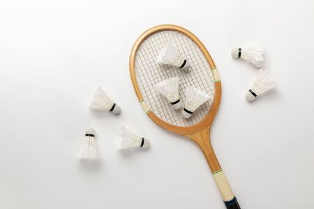 top view of wooden badminton racket and shuttlecocks on white backgroundの写真素材