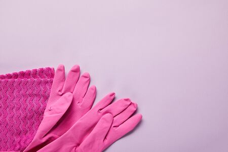 top view of pink rag, rubber gloves on purple backgroundの写真素材
