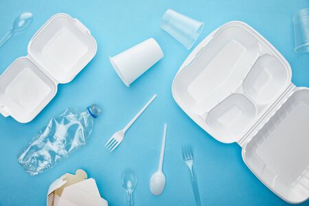 top view of plastic and cardboard rubbish on blue backgroundの写真素材