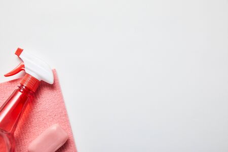 top view of pink rag, soap and bottle with spray on grey background