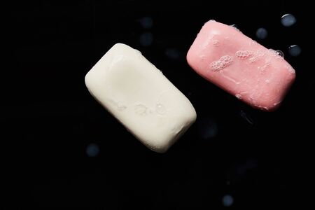 top view of pink and white soaps with drops on black backgroundの写真素材