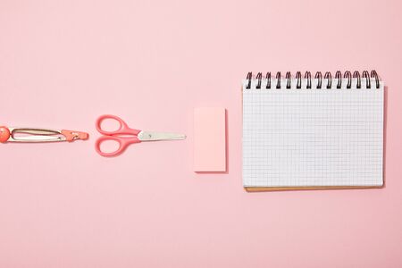 flat lay with school supplies near blank notebook isolated on pinkの写真素材