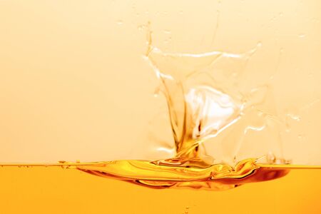 yellow bright liquid splash with drops isolated on yellow