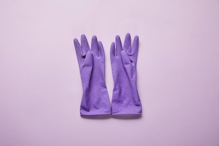 top view of bright and colorful rubber gloves on purple backgroundの写真素材