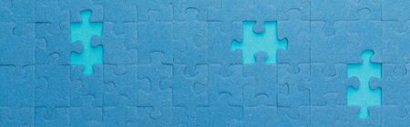 panoramic shot of blue jigsaw puzzle with lighter gapsの写真素材