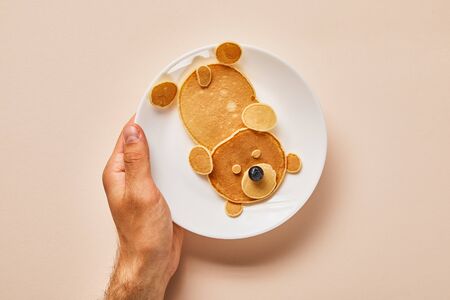 cropped view of pancakes on plate with one blueberry on pink, bear conceptの写真素材