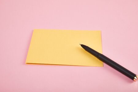yellow envelope with pen on pink backgroundの写真素材