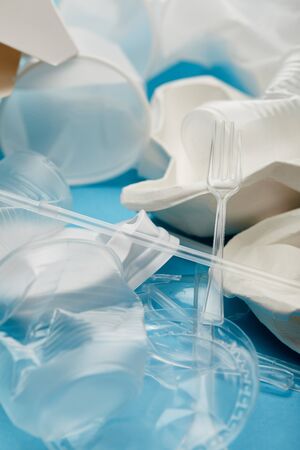 pile of crumpled plastic cups on blue background