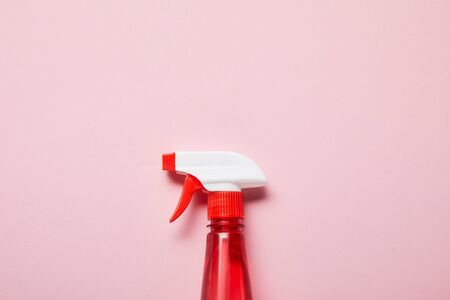 top view of red bottle with spray on pink background