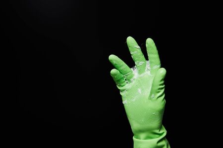 cropped view of man in rubber glove with foam isolated on black