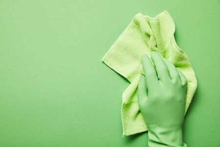 cropped view of man in rubber glove holding green rag