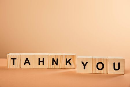 wooden cubes with thank you lettering on table isolated on beigeの写真素材