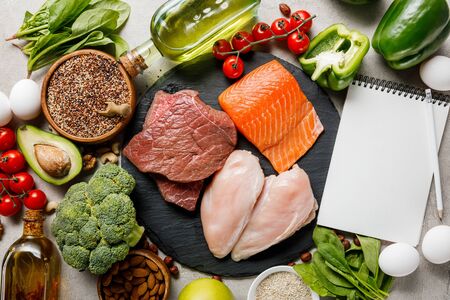 top view of blank notebook near raw meat and fish among fresh vegetables, ketogenic diet menuの写真素材