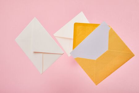 envelopes with blank white card on pink background