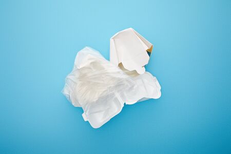 top view of plastic bag with disposable containers on blue background