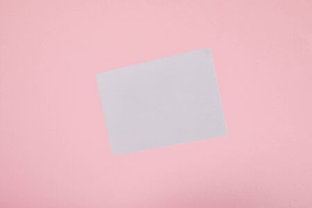 top view of blank white card on pink background