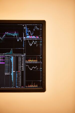 screen of digital device with charts and graphs in office