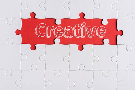 top view of connected jigsaw puzzle pieces near creative lettersの写真素材