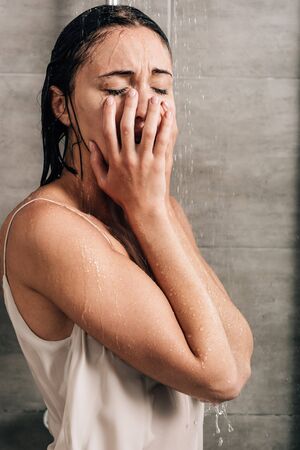 lonely sad woman crying in shower at homeの写真素材