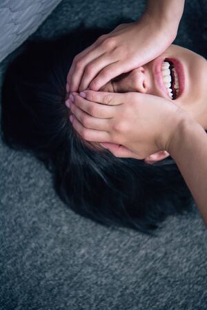depressed brunette woman covering face with hands and crying at home