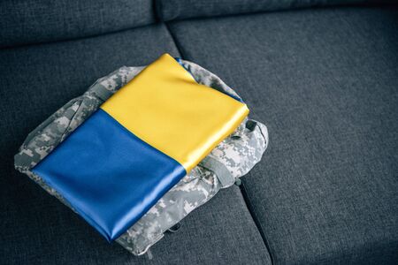 ukrainian flag and military clothing on couch at homeの写真素材