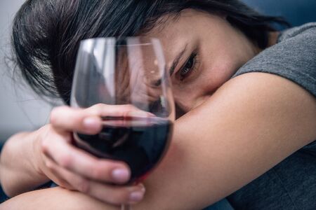 selective focus of depressed lonely woman with wine glass at home