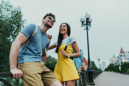 handsome man and asian woman smiling and looking away